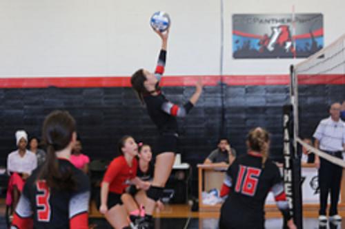 Women playing on volleyball court